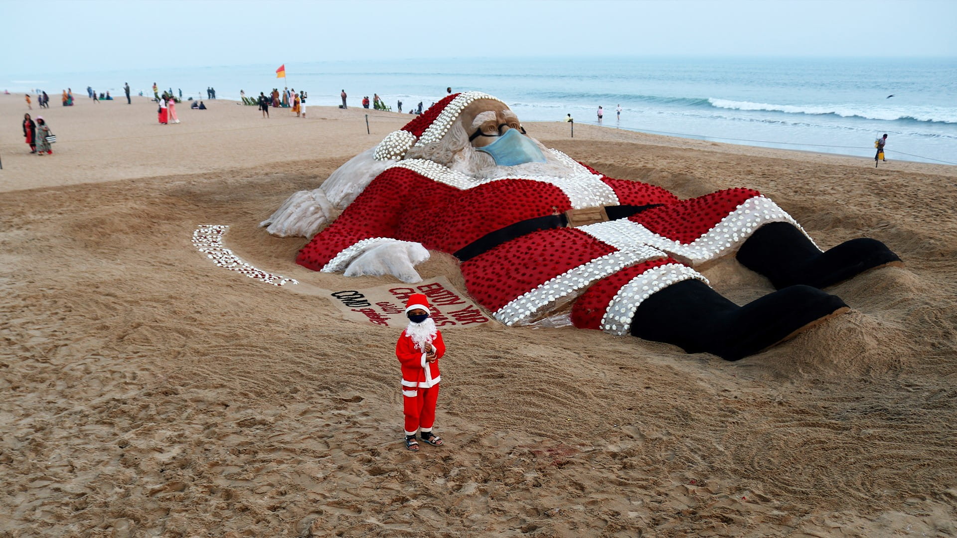 Image for the title: Giant Santa made of sand chills at Indian beach 