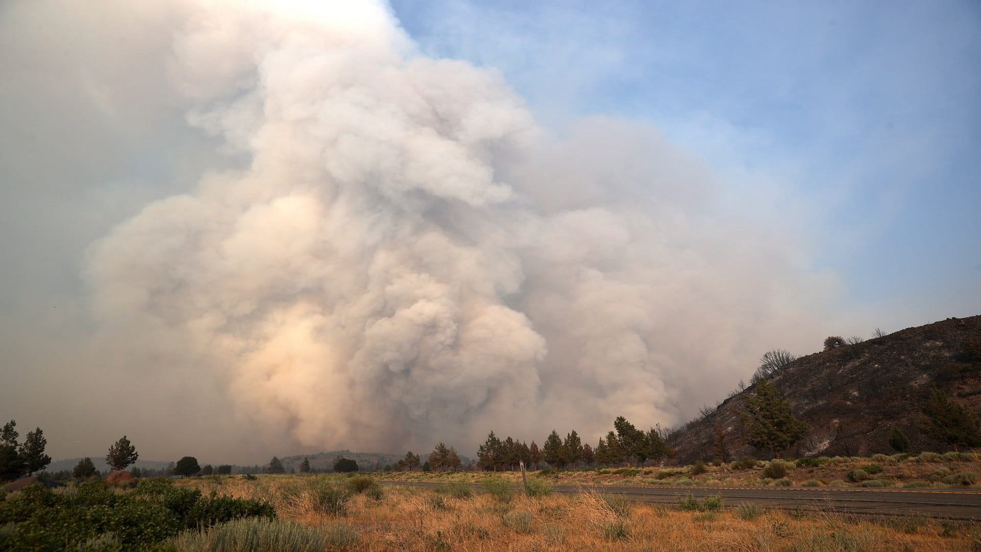 Image for the title: Wildfires rage across acres as heat wave stifles US, Canada 