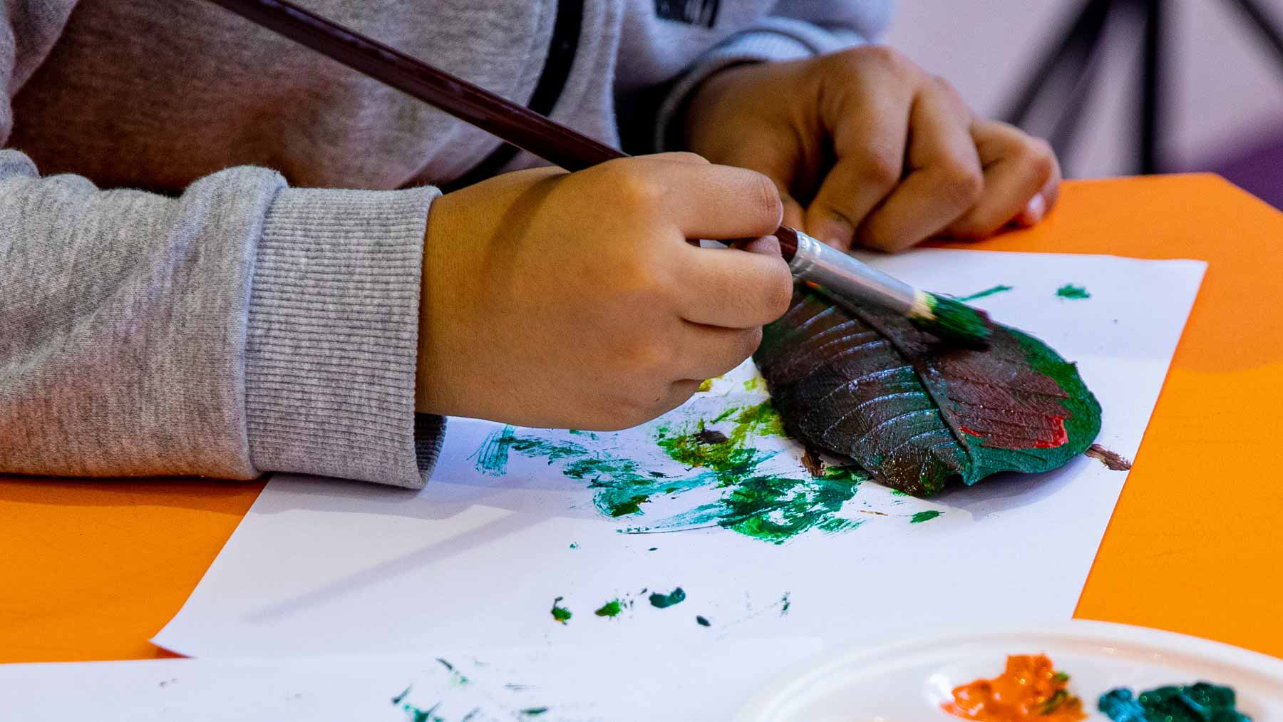 Image for the title: Children experiment with colours at ‘Leaf Printing’ SIBF workshop 