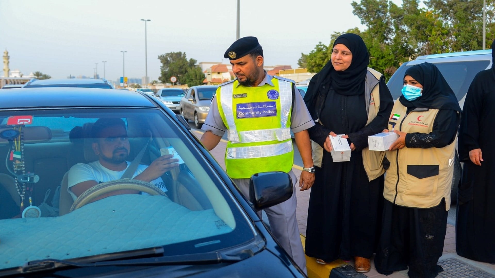 صورة بعنوان: شرطة الشارقة والهلال الأحمر توزعان وجبات إفطار صائم في مدن الإمارة 