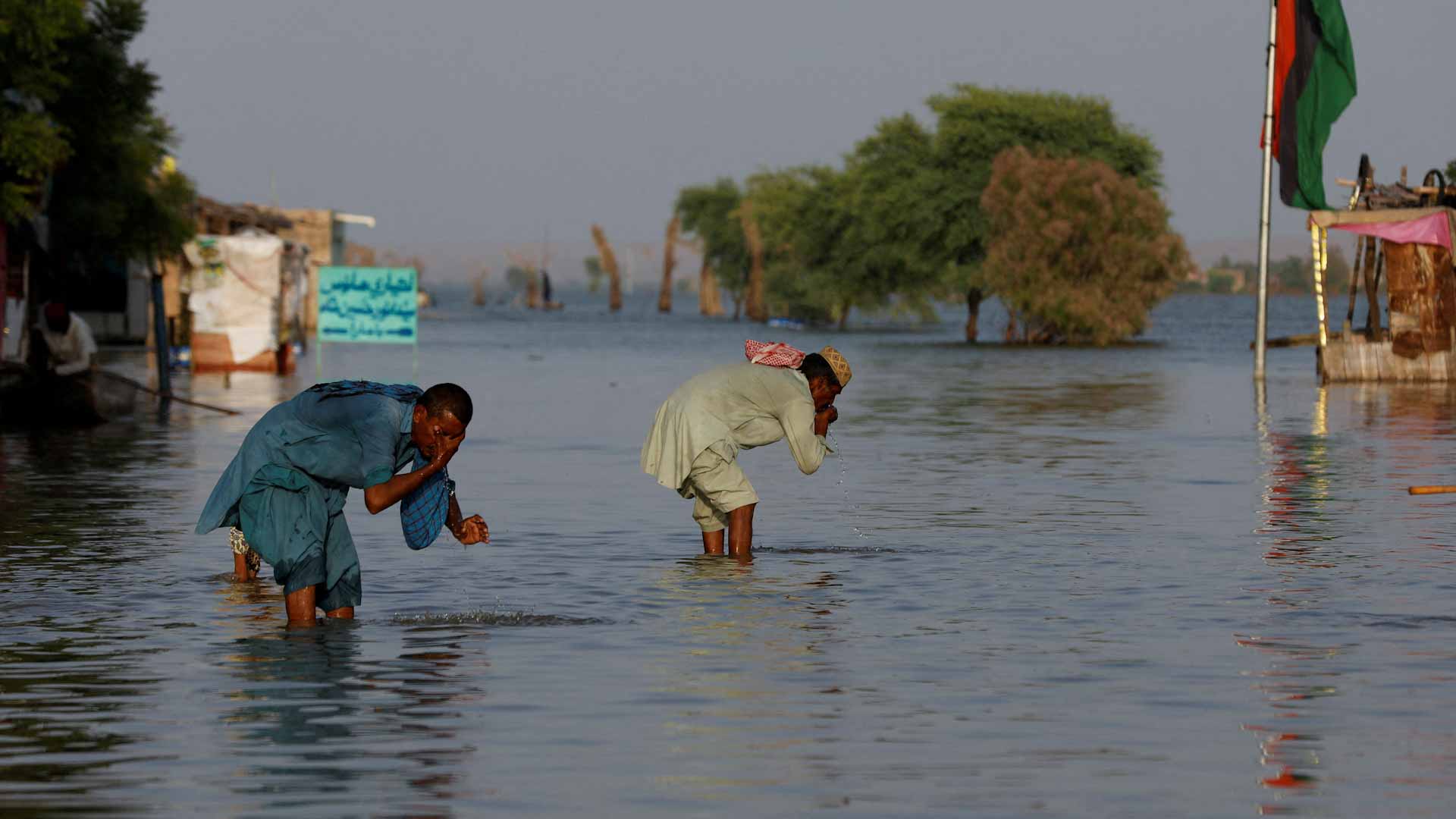 Image for the title: Pakistanis throw up barriers against rising flood; 12 died 