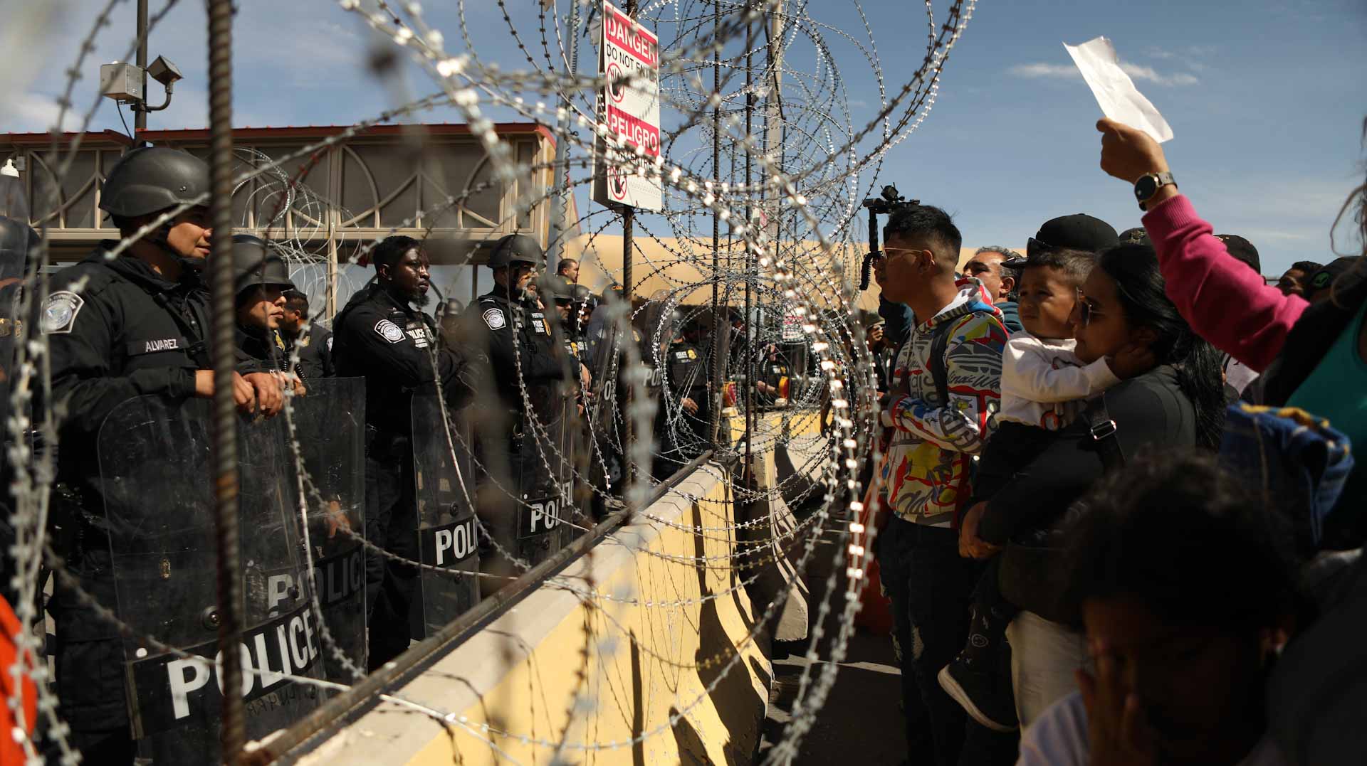 Image for the title: Hundreds of migrants try to force their way into US 