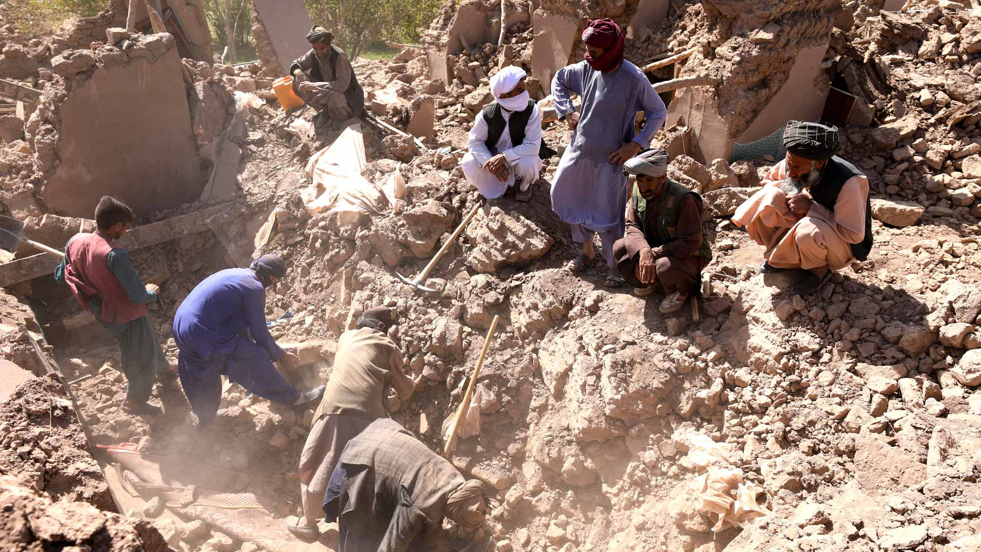 Image for the title: Volunteers dig for Afghan quake survivors as aid trickles in 