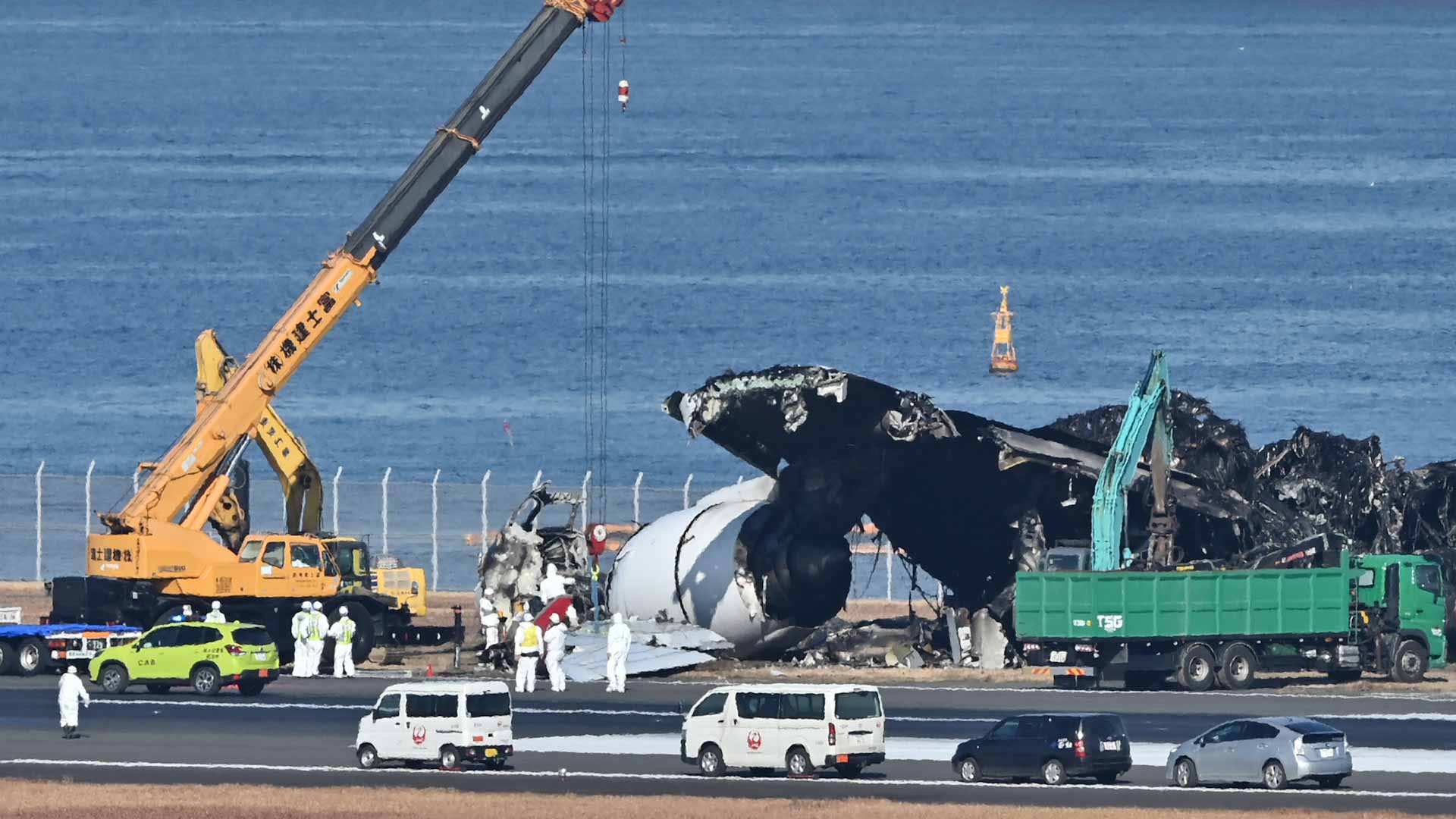 Image for the title: Plane wreckage being cleared from Tokyo airport after collision 