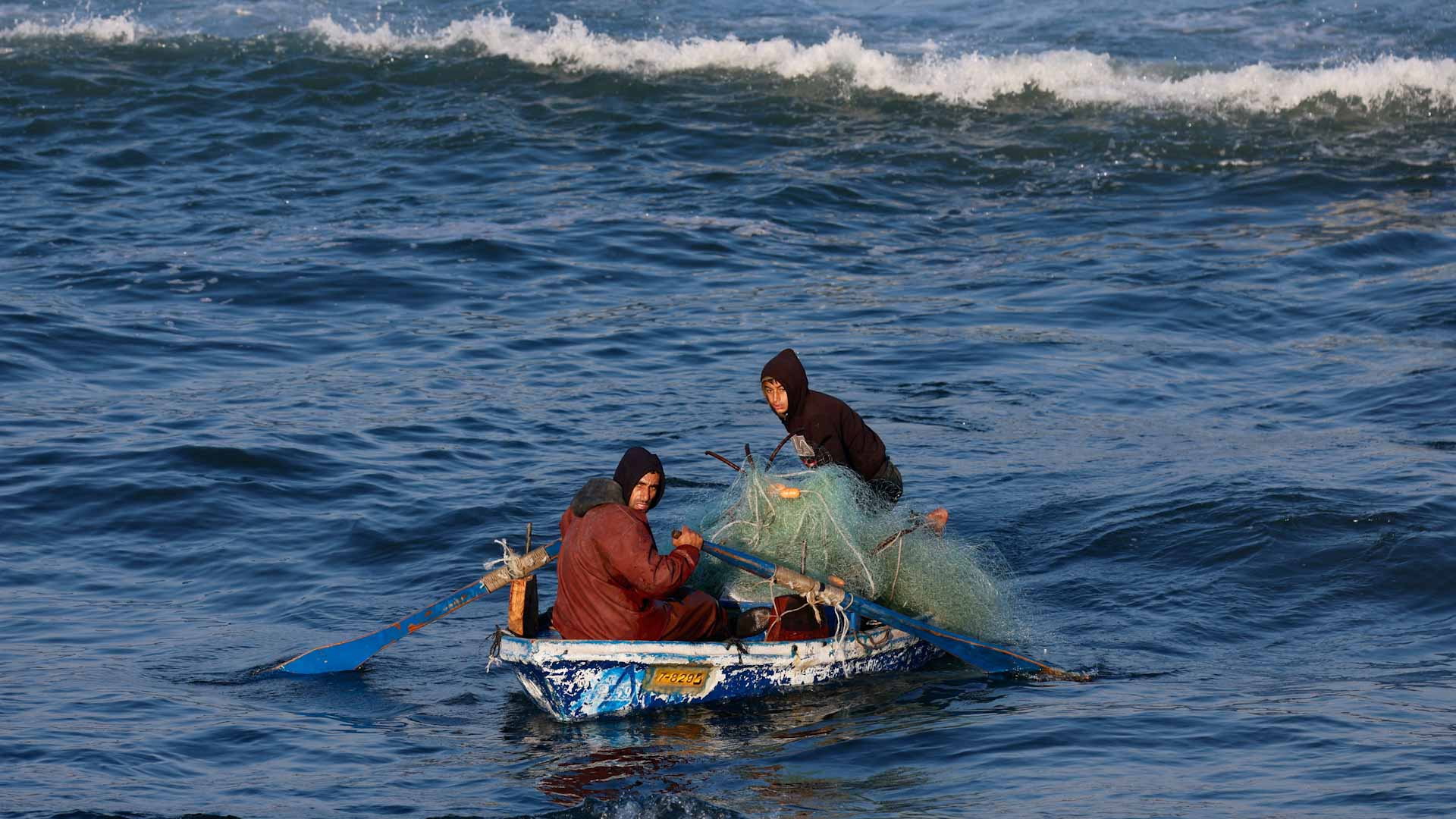 صورة بعنوان: رغم القصف..صيادو غزة يتحدون قذائف الموت لإطعام أسرهم من فتات البحر 