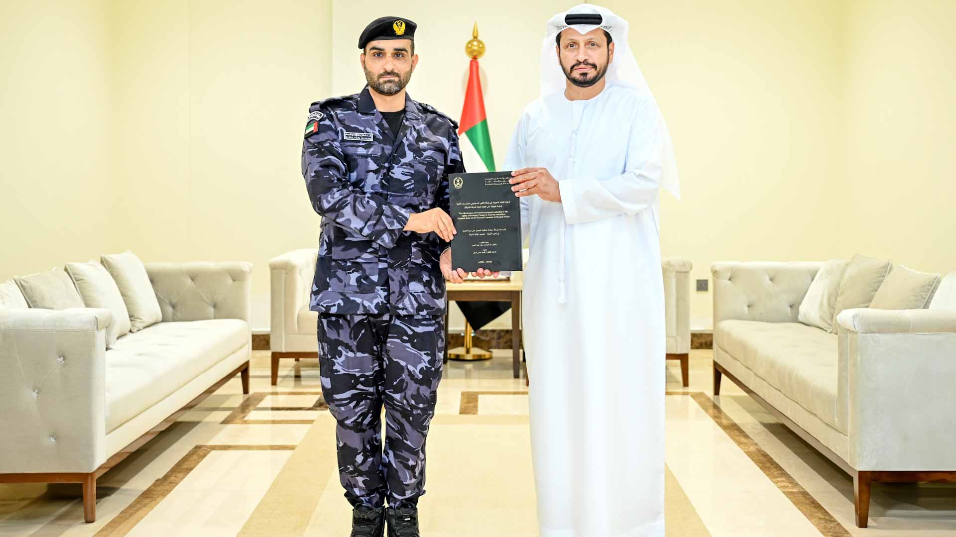 Image for the title: Al Shamsi congratulates an officer on obtaining a PhD 