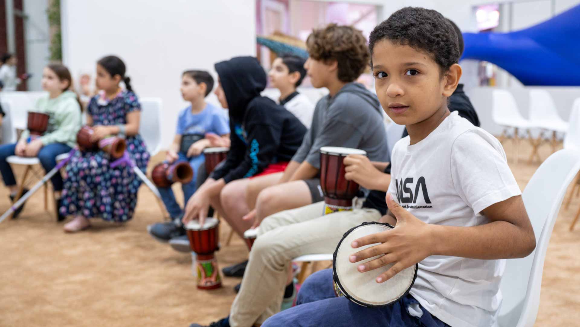 Image for the title: Children learn to drum the djembe like pros SCRF 2024 