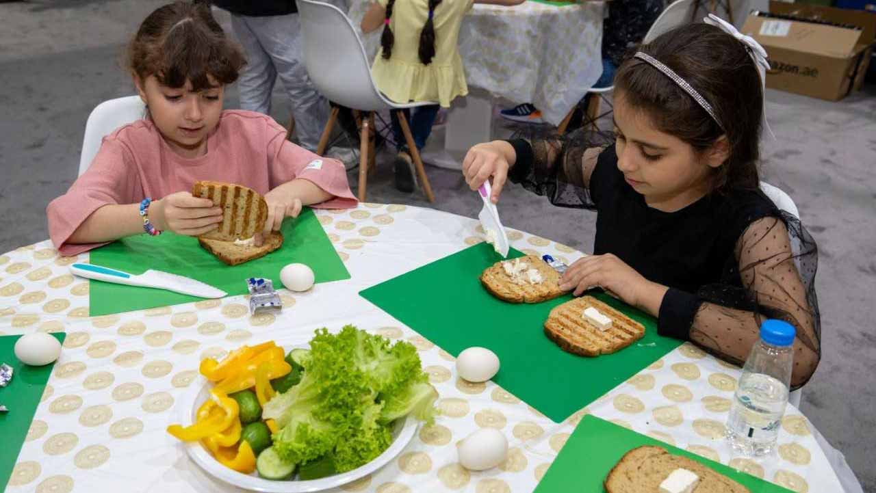 صورة بعنوان: الأطفال يحضرون وجبات صحية مقتبسة من قصة "ذات الرداء الأحمر" 