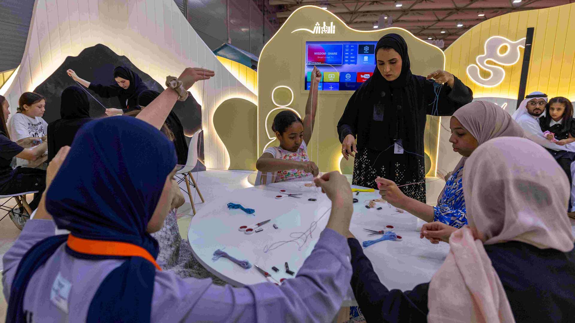 Image for the title: Braiding rope bracelets at SIBF keep girls in sync with fashion 