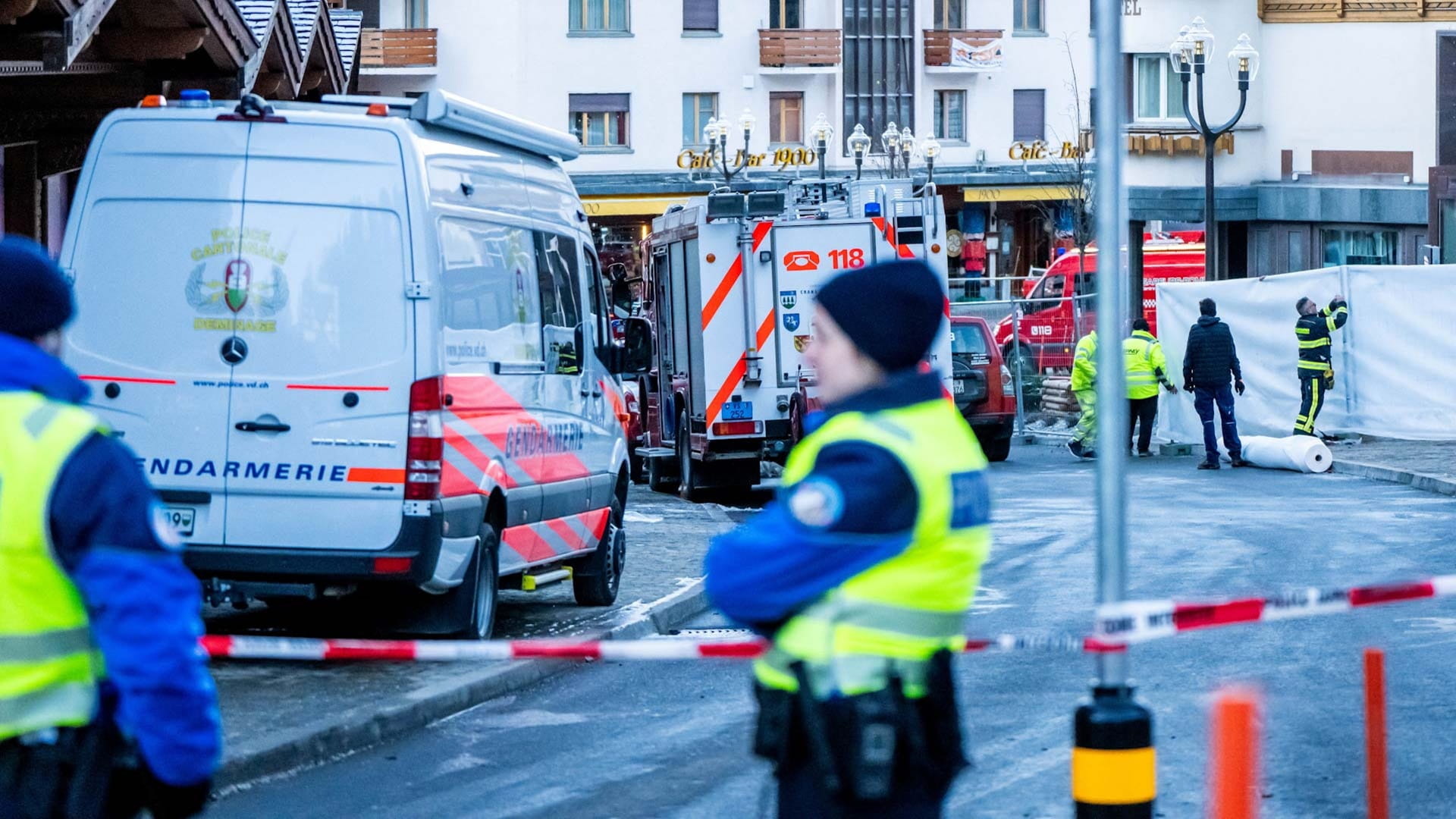 Police officers stand guard at the site of an explosion that ripped through the bar Le Constellation in Crans-Montana