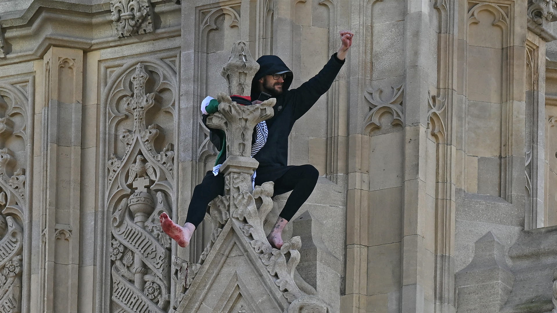رجل يتسلق برج بيغ بن في لندن رافعاً العلم الفلسطيني 