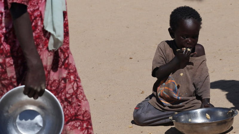 طفل سوداني يتناول وجبة مقدمة من "مشروع المطبخ الجماعي" داخل مخيم تين للعبور شرق تشاد